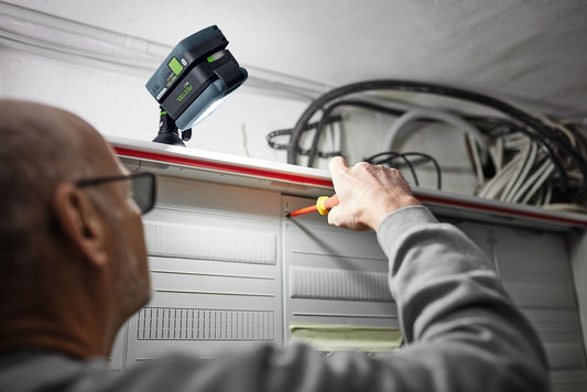 Festool SYSLITE KAL C Akku-Arbeitsleuchte im Einsatz an Deckeninstallation mit schwenkbarem Lampenkopf