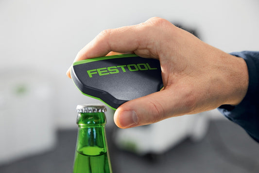 Festool Flaschenöffner BTTL-FT1 in Hand beim Öffnen einer Flasche, schwarz-grünes Design