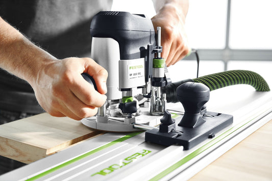 Festool OF 1010 Oberfräse mit Führungsschienen-Adapter auf Schiene montiert, in Anwendung beim Fräsen von Holz