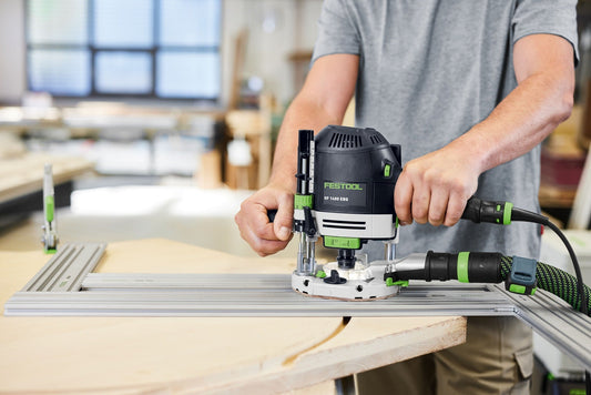 Festool OF 1400 EBQ Oberfräse bei der Anwendung auf Werkstück in Werkstatt mit LED-Licht und Absauganlage