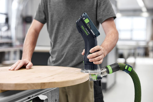 Festool OFKC 500 Akku-Kantenfräse im Einsatz beim Abrunden einer Holzkante mit Absaugschlauch