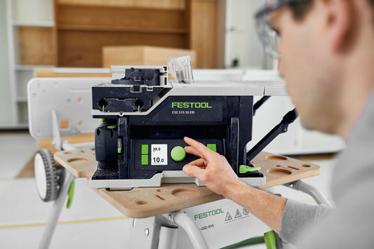 Festool CSC SYS 50 EB Akku-Tischkreissäge mit digitalem Display, Bedienung durch Hand auf Holzwerkstück in Werkstatt
