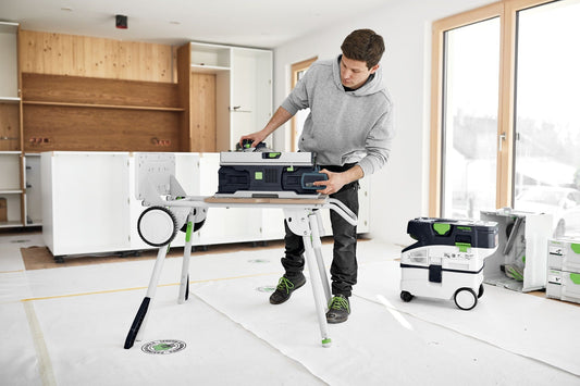 Festool Akku-Tischkreissäge CSC SYS 50 EB-Basic auf Arbeitstisch, Handwerker bedient digitales Display zur Höheneinstellung