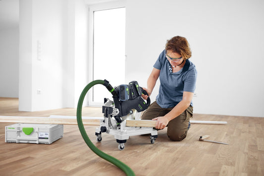 Festool SYMC 70 EB-Basic Akku-Leistensäge beim Leistenschnitt auf Holzleisten mit grünem Absaugschlauch