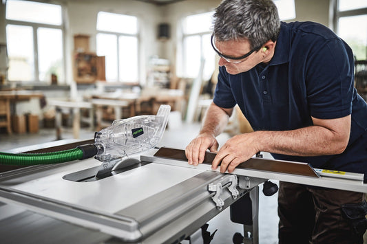 Festool TKS 80 EBS ST 840 Tischkreissäge mit Absaughaube beim Sägen von Holz, Handanleitung des Bedieners