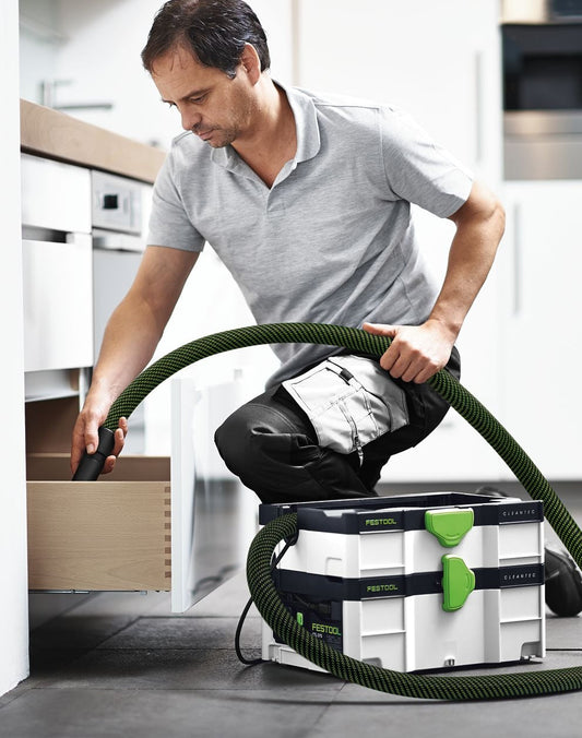 Festool Absaugmobil CLEANTEC CTL SYS mit Schlauch beim Absaugen von Holzstaub in der Küche