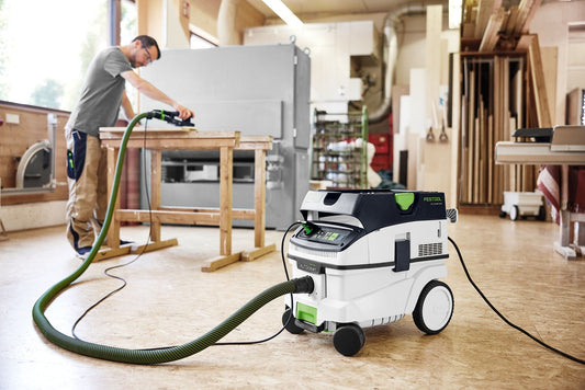 Festool CLEANTEC CTM 26 EI AC Absaugmobil mit grünem Schlauch im Einsatz in Werkstatt, automatische Filterabreinigung