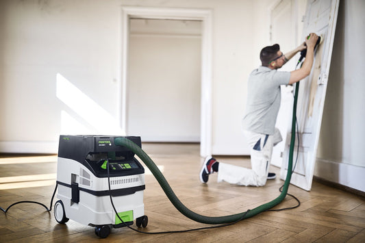 Festool CLEANTEC CTL MIDI I Absaugmobil im Einsatz bei Trockenbauarbeiten mit angeschlossener Absauganlage.