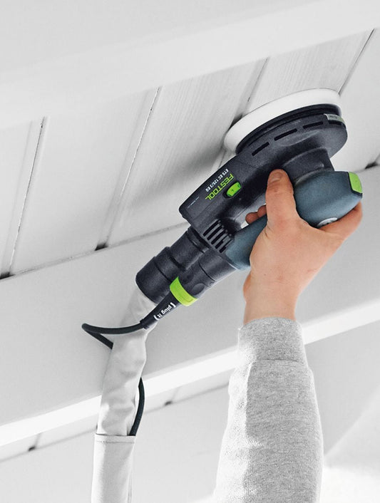 Festool Schleifteller mit Klettbelag wird auf Deckenoberfläche angewendet, schwarzer Schleifer mit grünen Elementen in Hand
