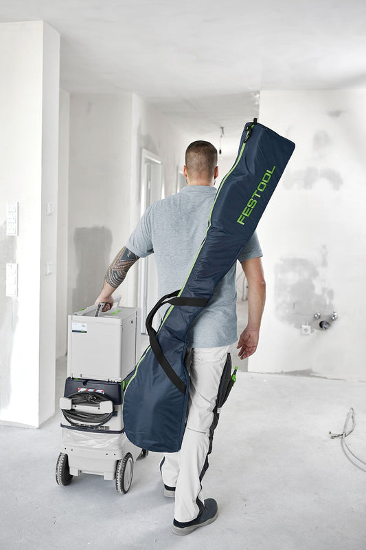 Festool PLANEX Transporttasche mit Schulterriemen, Handwerker trägt Langhalsschleifer-Tasche auf Baustelle