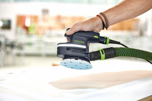 Festool Kompaktschleiffer mit LED-Lichtmodul LM-DTS beim Schleifen auf Holzoberfläche, blaue Schleifteller mit Lochung
