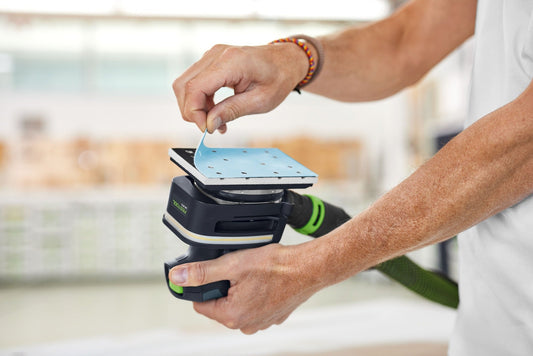 Festool Lichtmodul LM-RTS mit LED-COB-Technik, Montage auf Kompaktschleifer, Hände zeigen Wechsel des Schleiftellers
