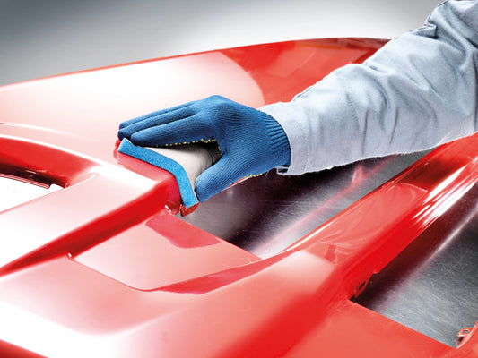 Anwendung der sia 7983 siasponge flex Pads beim Handschleifen eines roten Karosserieteils – ideal für Lack, Kunststoff und geschwungene Oberflächen.